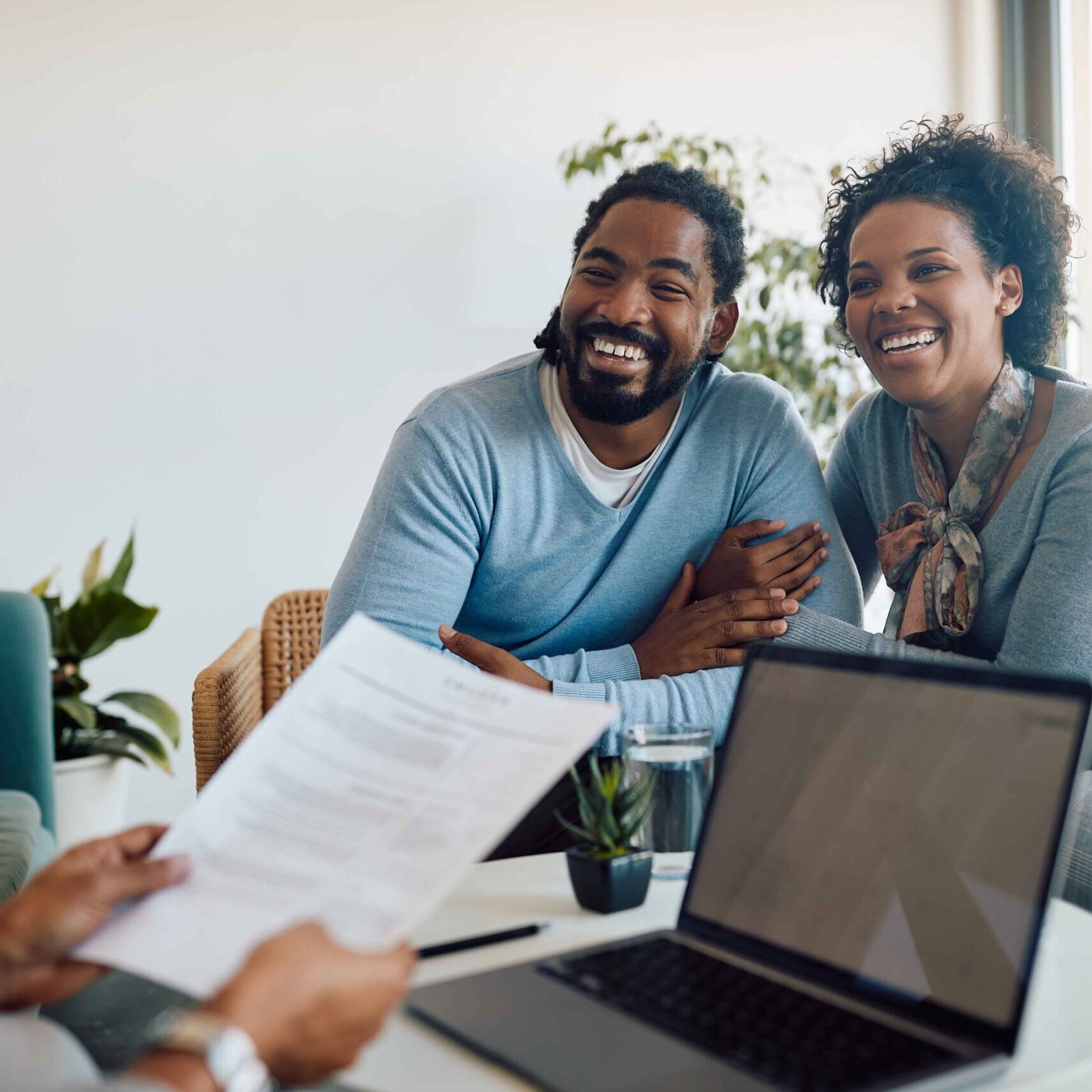 Happy black couple having meeting with their insurance agent in office.